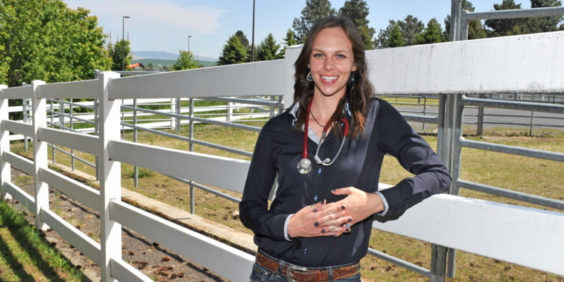 Haley Primley standing near a fence outside the veterinary teaching hospital