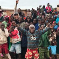 Rachel Clark standing in the middle of about 3 dozen children