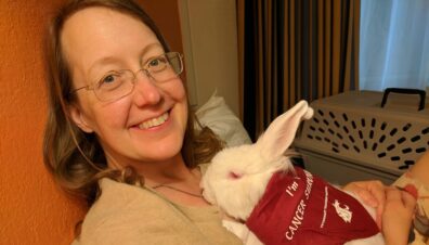 Paula holding Zsa Zsa who is wearing and I'm a Cancer Survivor scarf