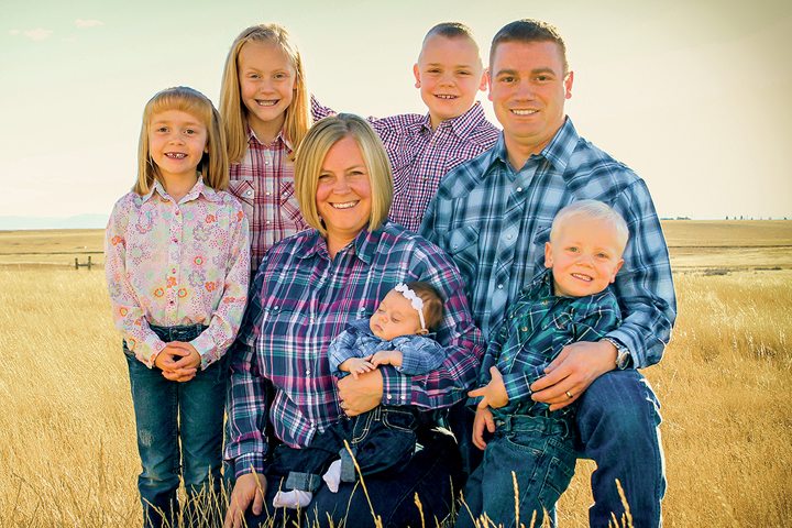 Shawn Sanders ('09 DVM) and family in a field in the Fall.