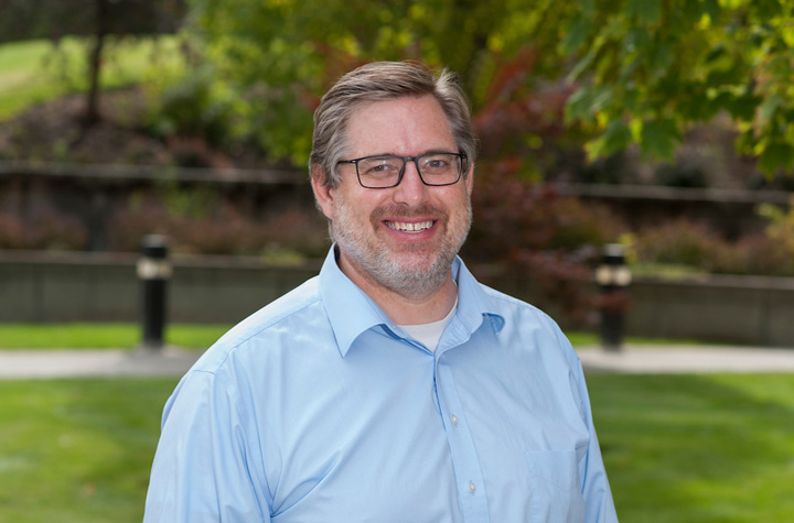 Dr. Jeff Abbott standing outside the college on a summer day.
