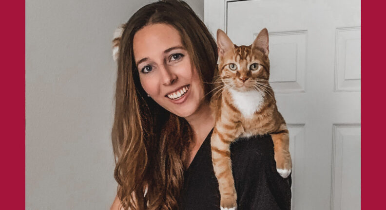 Nicole with her orange tabby on her shoulder.
