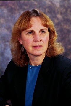 Professional headshot of Dr. Tornquist in a photo studio. She's wearing a dark jacket over a royal blue top.