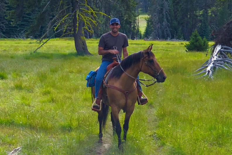 Conrad on his horse on a mountain trail.