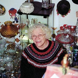 Anita surrounded by antiques in a shop.