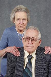 Studio photo of Dr. Davis and his wife. Simple gray background.