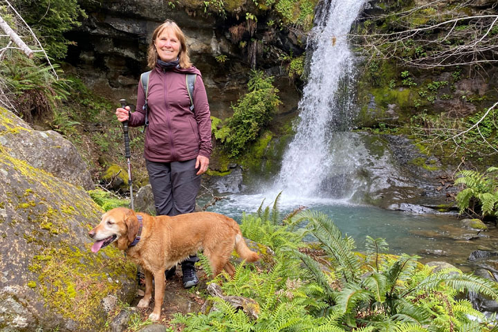 Dr. Tornquist and her dog by a small waterfall.