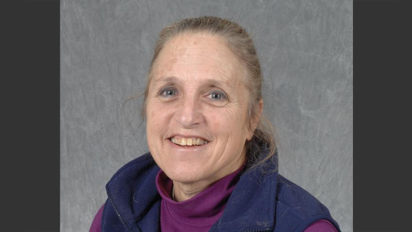 Jenifer Gold with a simple grey background in a photo studio.