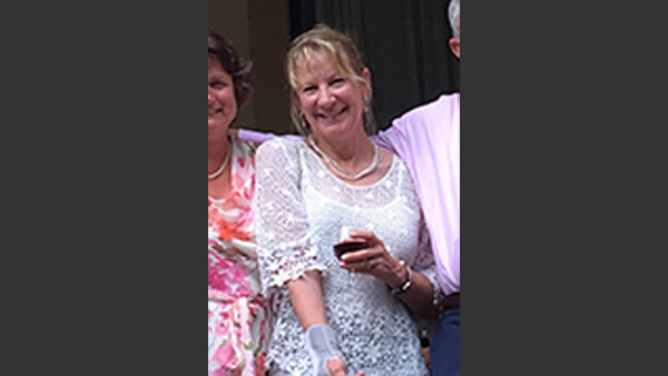 Char with friends at a formal event. She is wearing a lacey white dress.
