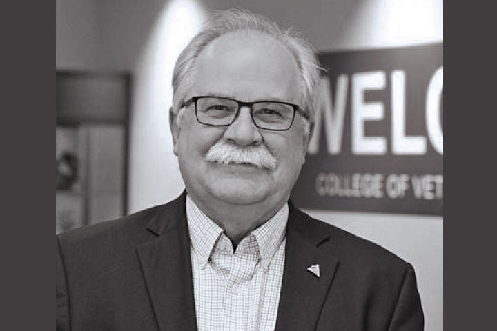Black and white image of Bryan Slinker in the Bustad Hall lobby.