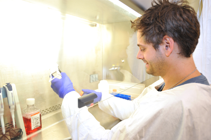 Dr. Letko working under a hood in a lab.