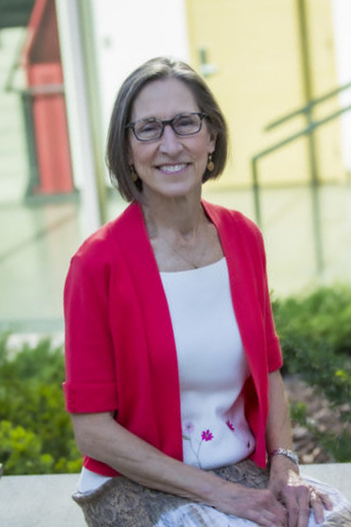 Dr. Phyllis Erdman sitting outside on the concrete bench.