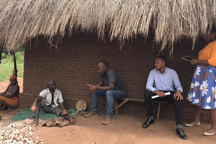 Kennedy sitting next to a brick home with 4 others.