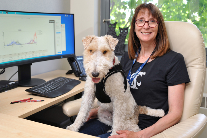 Dr. Katrina Mealey at her desk, with her dog.