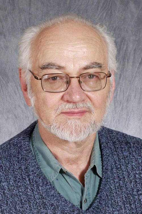 Professional photo of Dr. Jaak Panksepp in a photo studio with a simple grey backdrop.