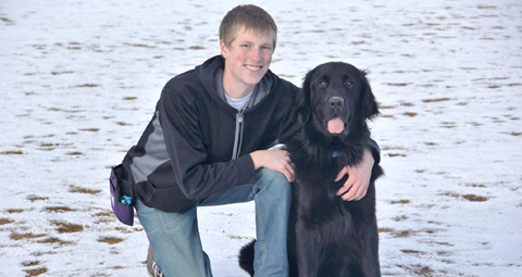 Andrew with his dog in a snowy field.