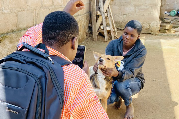 Maliki photographing a boy's dog.