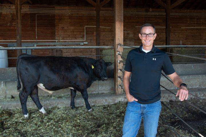 Dr. Jon Oatley stands near a cow.