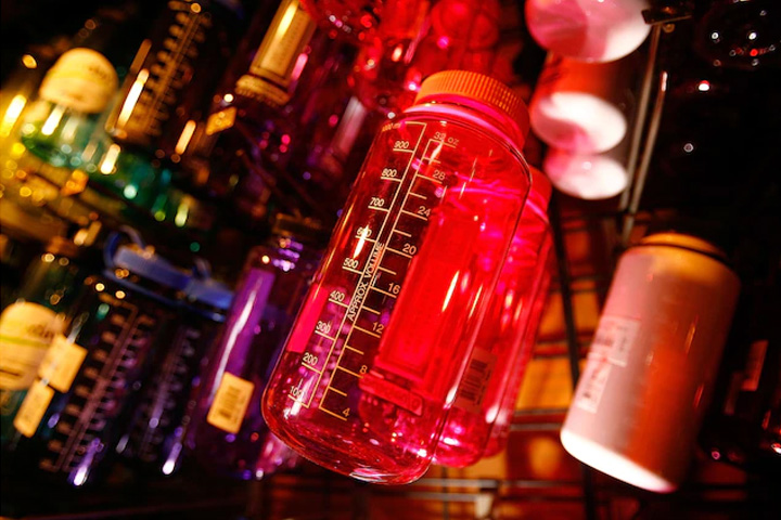 A multitude of water bottles hanging on a display to sell.