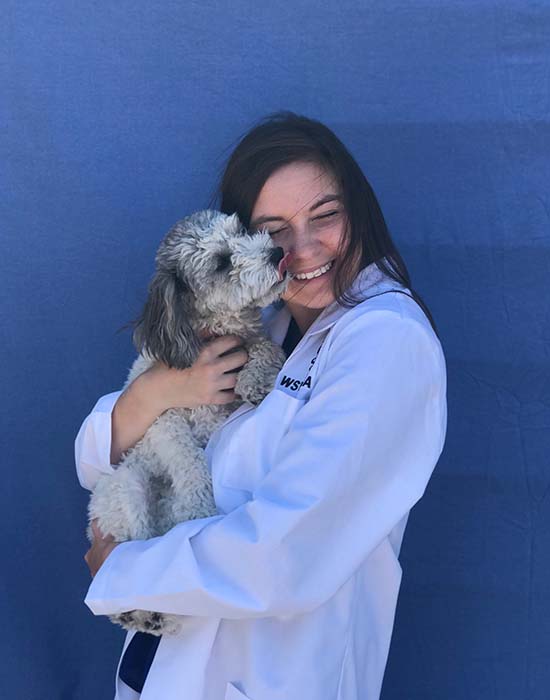 Deleaney Clem hugging a small dog.