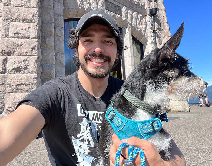 Chris taking a selfie with his dog on a sunny day.