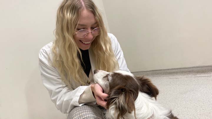 Veronica with Border Collie in a hallway at the Teaching Hospital.