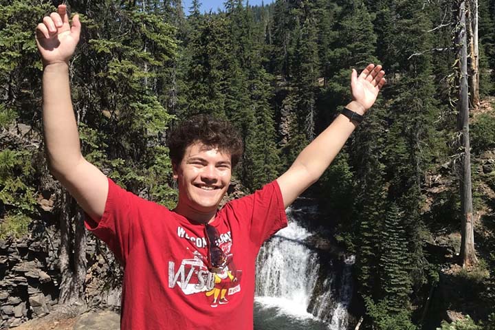 Stepehn with a mountain waterfall behind him.