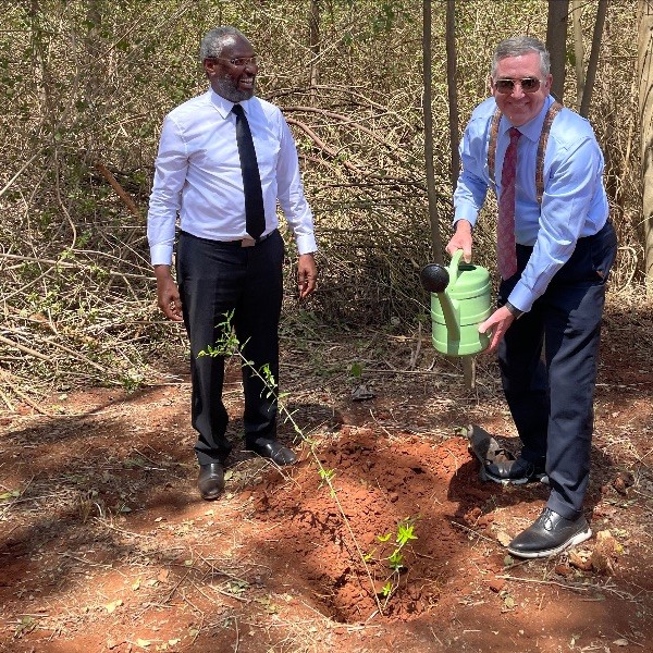 WSU President Schultz and Mr. Kiama standing by a tree that they just planted.