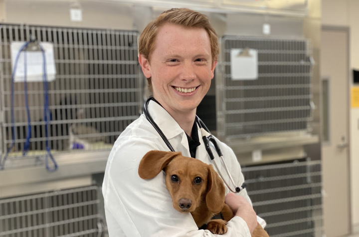 Nick, holding a young Dachshund, while in the Veterinary Teaching Hospital.