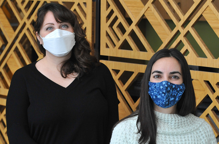 Stephanie Seifert and Pilar Fernandez (wearing masks) inside the Paul G. Allen School for Global Health.
