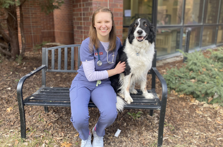 Christina sitting outside the Veterinary Teaching Hospital with her dog, Huckleberry.