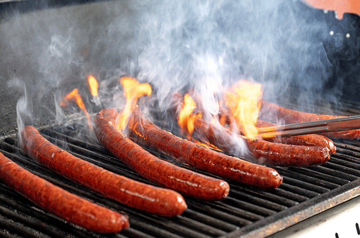 WSU Meat Scientist Blake Foraker grills a batch of sausage made with pork from gene-edited pigs for a cookout celebrating Professor Jon Oatley's research team on the WSU Pullman campus.