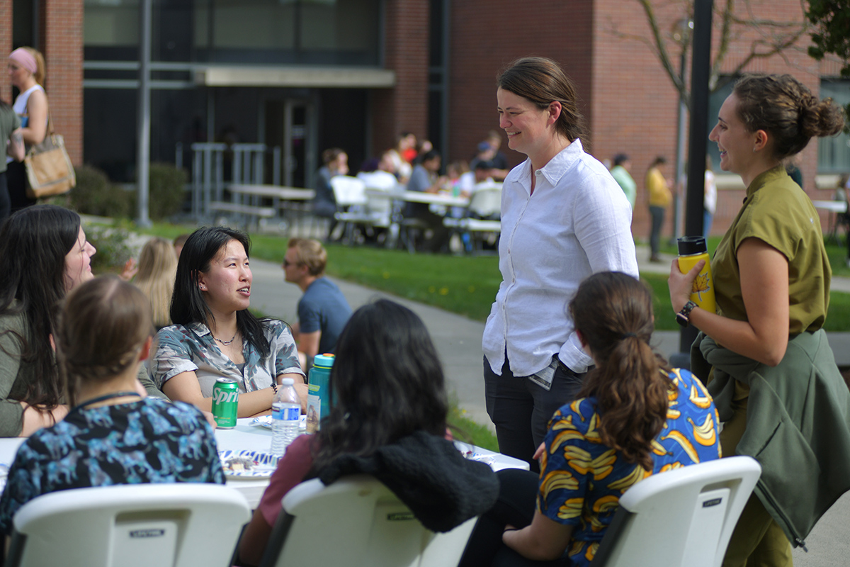 Members of the DVM class of 2023 enjoying a graduation BBQ. Some people at a table and others standing.