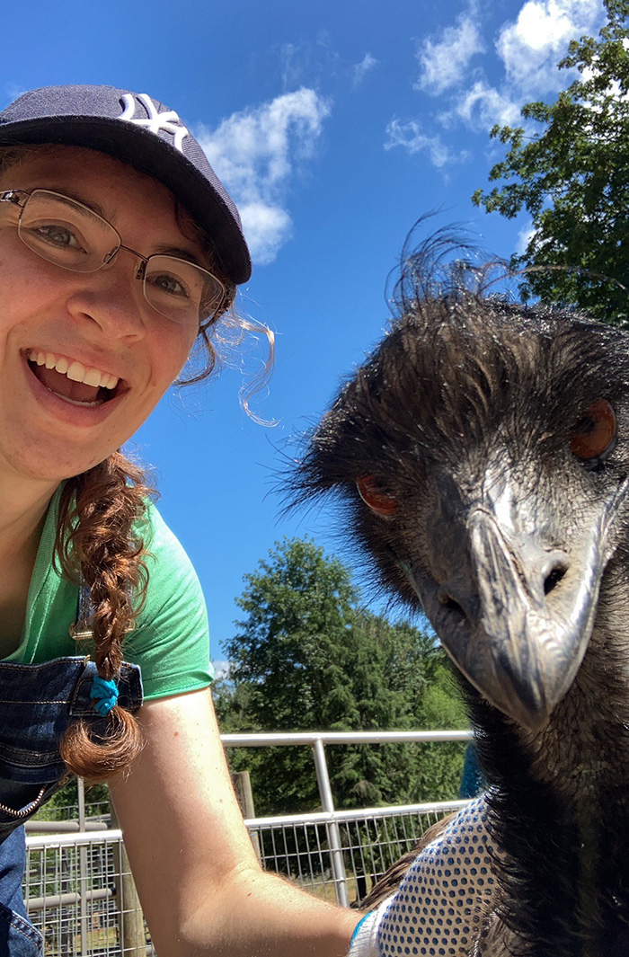 Clarice taking a selfie with an emu who is very interested in the camera.