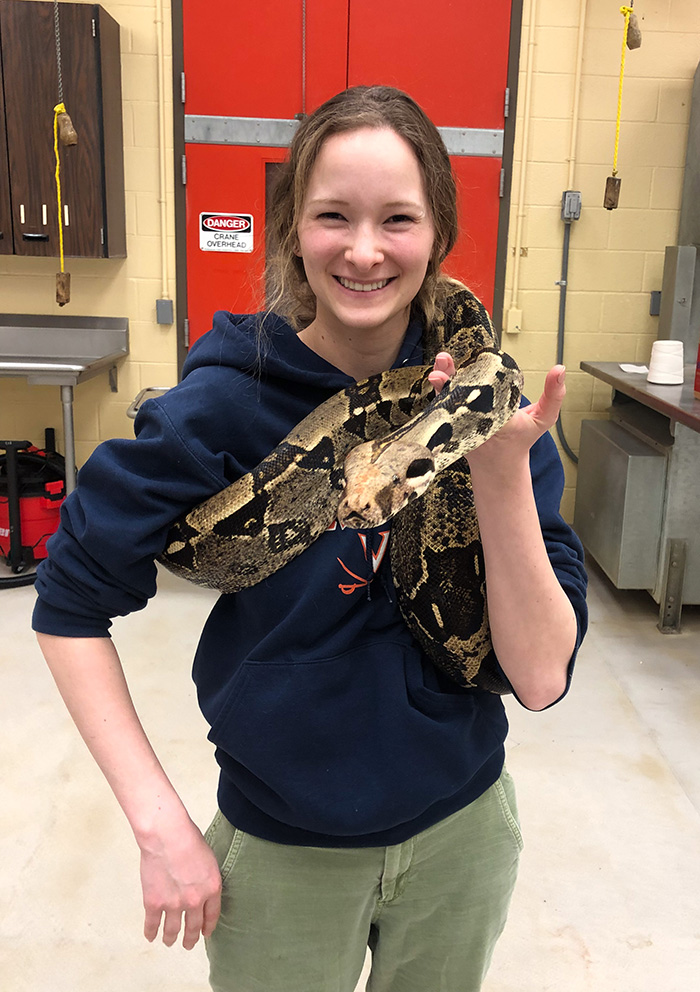 Alina holding a large snake in the Exotics area of the Teaching Hospital.