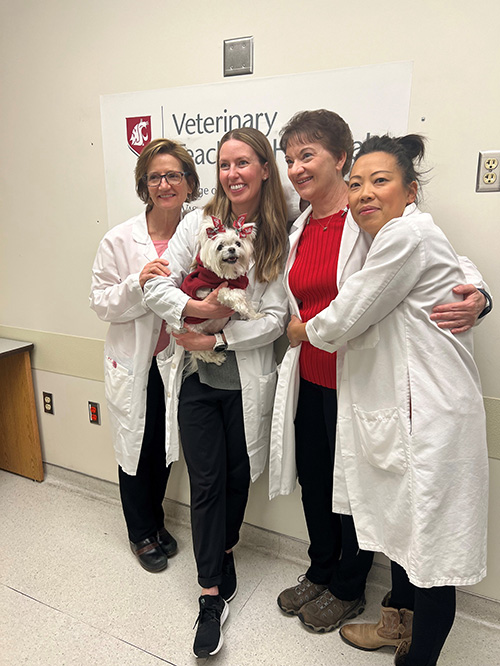 Mille with caregivers in a hallway in the Teaching Hospital.