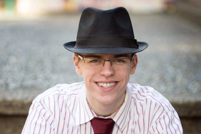 Nolan sitting on steps outside on campus.