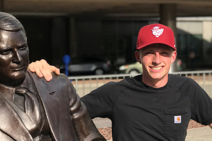 Pierce sitting on the steps next to a statue outside the clinic.