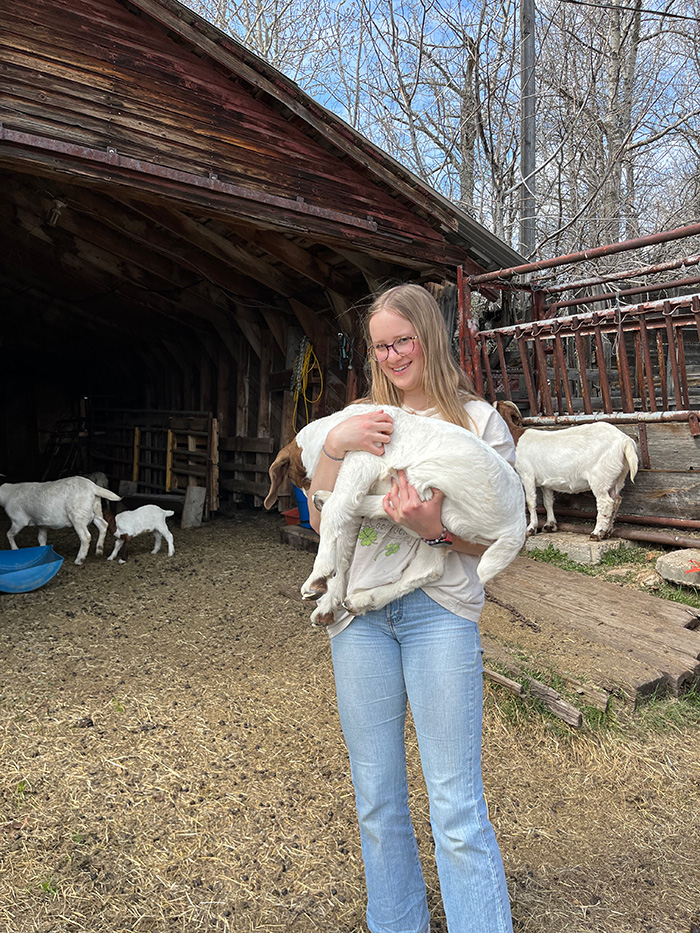 Brooklyn with goats at her home.