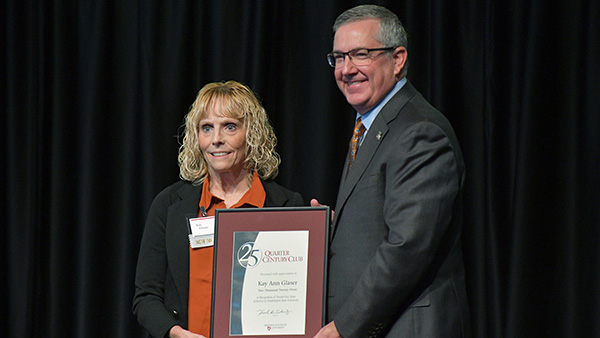 Kay Glaser receiving a Quarter Century certificate from WSU President Kirk H. Schulz.