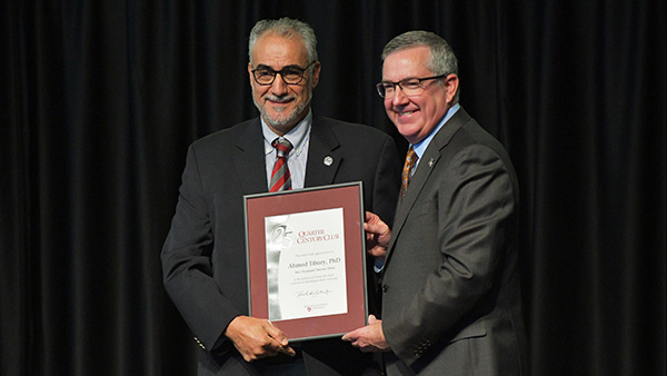 Dr. Ahmed Tibary receiving a Quarter Century certificate from WSU President Kirk H. Schulz.