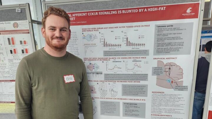 Eric standing in front of one of his research posters.