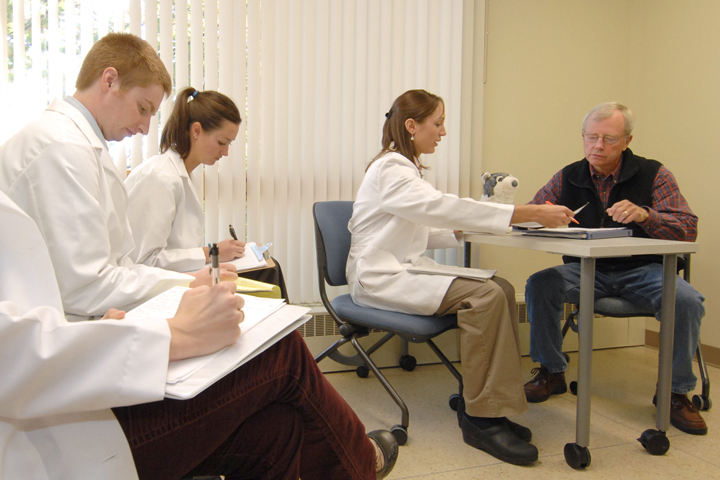 Students in a room with a volunteer client.