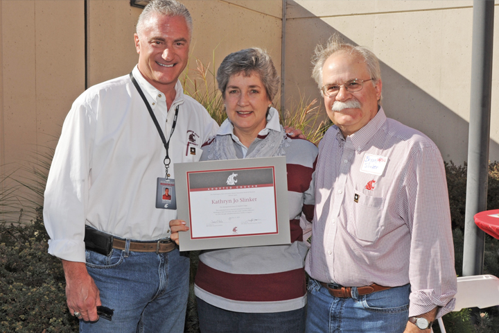 Kathy Slinker receiving her Adopted Cougar certificate with Bryan Slinker (right) and Tim Pavish, executive director of alumni relations.