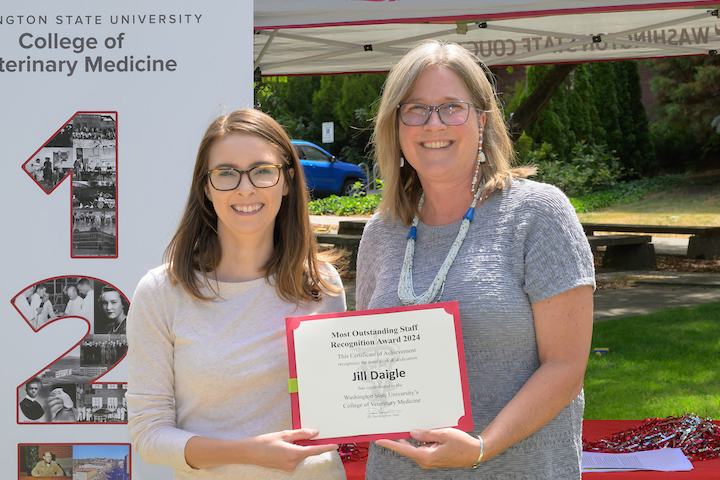 Jill holding her certificate as she is standing with Dean Dori.