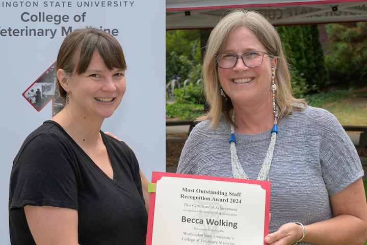 Becca holding her certificate as she is standing with Dean Dori.