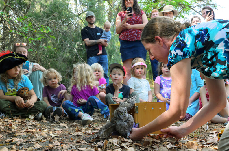 Dr. Marcie Logsdon, right, prepares to release a western screech owl at the Palouse-Clearwater Environmental Institute. Child are watching.
