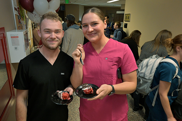 Two people after they just received their piece of cake.