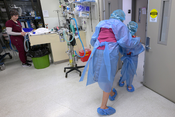 Maddie Hedrick wears surgical scrubs as she walks with Raelynn Farnsworth.