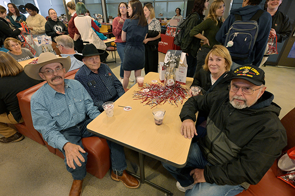 Crowd, seated and standing, in the Mickelsen Lounge during the 125 celebration. A group of older alums are in the forground.
